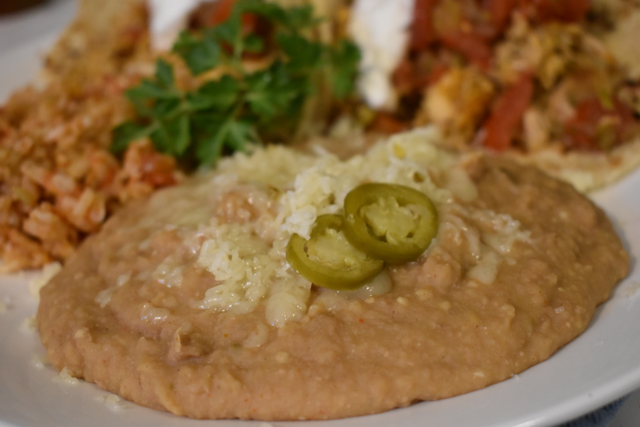 Refried beans topped with shredded cheese and pickled jalapenos